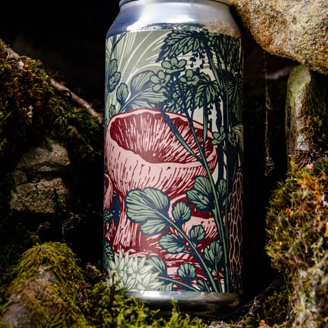 A slim aluminum craft beer can with a detailed botanical mushroom illustration, set in a natural mossy rock environment.